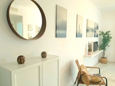 a mirror on a wall above a white cabinet in a room at Sherryflat Neira - Parking in Jerez de la Frontera