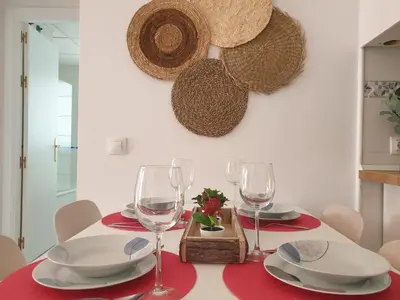 a dining room table with glasses and plates on it at Sherryflat Neira - Parking in Jerez de la Frontera