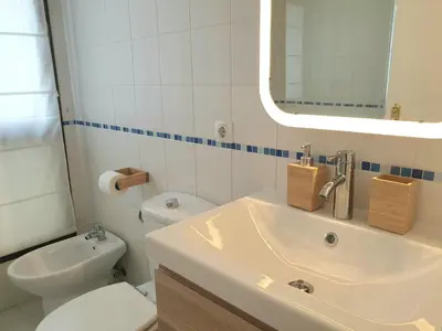 a bathroom with a sink and a toilet and a mirror at Sherryflat Neira - Parking in Jerez de la Frontera