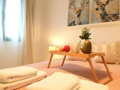 a bed with a table with towels and fruit on it at Sherryflat Neira - Parking in Jerez de la Frontera
