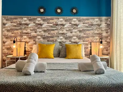 a bedroom with a large bed with yellow pillows at GATU El Galeno Del Puerto 4 dormit, 2 baños, aire acc en el centro histórico, 