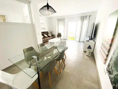 a living room with a glass table and chairs at Casa moderna, piscina, playa, TV75, Netflix, PS4 in Conil de la Frontera