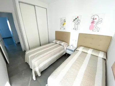 two beds in a room with drawings on the wall at Casa moderna, piscina, playa, TV75, Netflix, PS4 in Conil de la Frontera