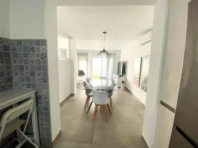 a kitchen and dining room with a table and chairs at Casa moderna, piscina, playa, TV75, Netflix, PS4 in Conil de la Frontera