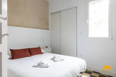 a white bedroom with a bed with towels on it at La Casa del Alfarero by Cadiz Time in Cádiz