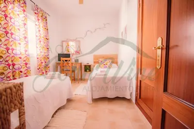 a room with a bed and a table and a door at La casa de John Wine , Bornos (Spain) in Bornos