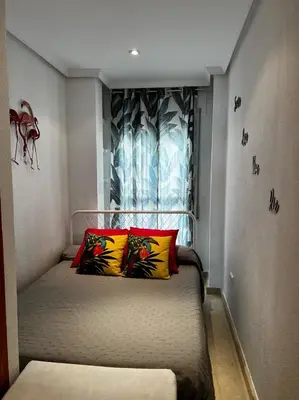 a bedroom with a bed with two colorful pillows at Ático Good Vibes in Rota