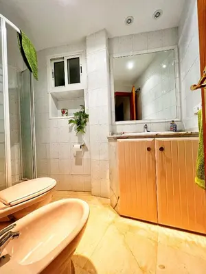 a bathroom with a sink and a toilet and a mirror at Ático Good Vibes in Rota