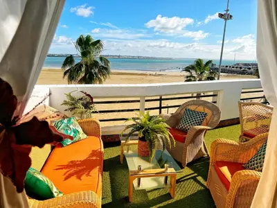 a balcony with chairs and a view of the beach at Ático Good Vibes in Rota