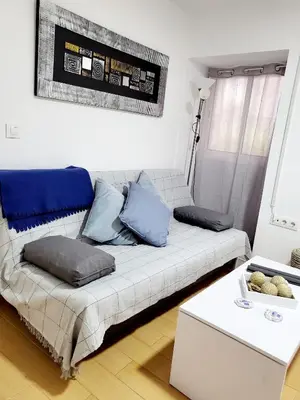 a living room with a white couch with blue pillows at Twins' Home Ponce, Jerez Centro, Cádiz, wifi in Jerez de la Frontera