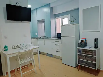 a kitchen with a white refrigerator and a table at Twins' Home Ponce, Jerez Centro, Cádiz, wifi in Jerez de la Frontera