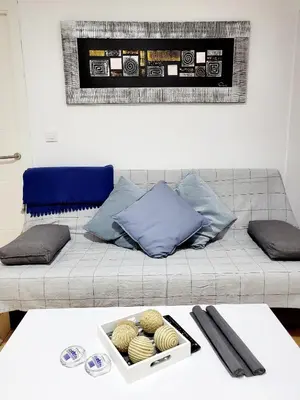 a couch with pillows and a tray on a table at Twins' Home Ponce, Jerez Centro, Cádiz, wifi in Jerez de la Frontera