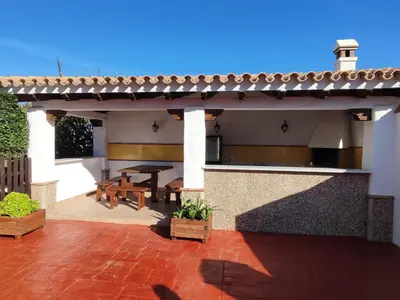 a patio of a house with a table and benches at Casa Antonia in Conil de la Frontera
