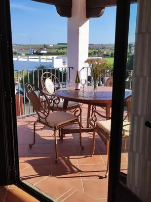 a table and chairs on a balcony with a view at Casa Antonia in Conil de la Frontera
