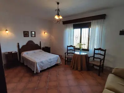 a bedroom with a bed and a table with chairs at Casa Antonia in Conil de la Frontera