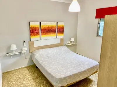 a bedroom with a bed and three windows at Apartamentos turísticos en Jerez de la frontera in Jerez de la Frontera