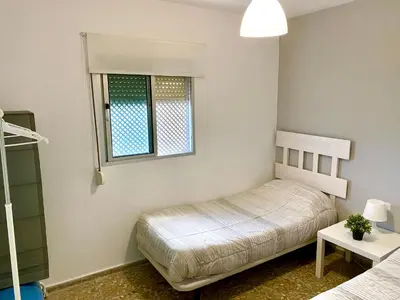 a bedroom with two beds and a window at Apartamentos turísticos en Jerez de la frontera in Jerez de la Frontera
