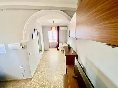 a hallway with an archway and a kitchen with a table at Apartamentos turísticos en Jerez de la frontera in Jerez de la Frontera