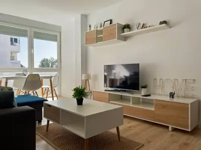 a living room with a couch and a tv and a table at Apartamento Aurora - Ole Solutions in El Puerto de Santa María