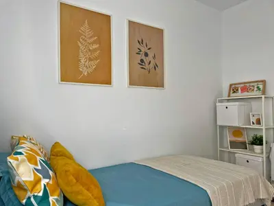 a bedroom with a bed and two pictures on the wall at Apartamento Aurora - Ole Solutions in El Puerto de Santa María