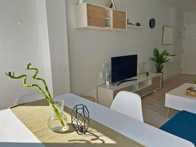 a living room with a table and a vase with a plant at Apartamento Aurora - Ole Solutions in El Puerto de Santa María