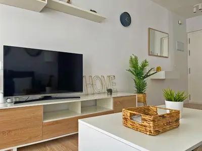 a living room with a flat screen tv on a entertainment center at Apartamento Aurora - Ole Solutions in El Puerto de Santa María