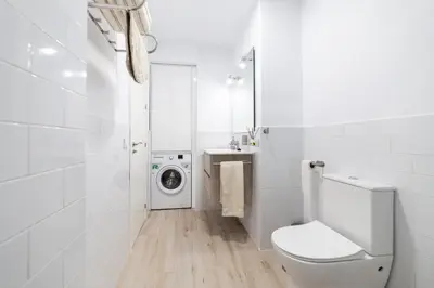 a bathroom with a toilet and a washing machine at Loft en el corazón de Cádiz con opción a Parking in Cádiz