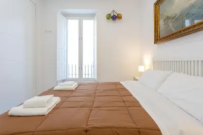 a bedroom with a large bed with two pillows on it at Apartamento El SEMINARISTA by Cadiz4Rentals in Cádiz