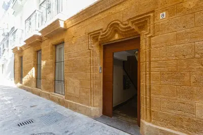 a brown brick building with a door on a street at Apartamento El SEMINARISTA by Cadiz4Rentals in Cádiz