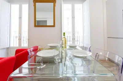 a dining room with a glass table and red chairs at Apartamento El SEMINARISTA by Cadiz4Rentals in Cádiz