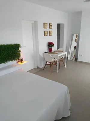 a white room with a table and chairs and a bed at Apartamentos Los Cabezuelos, Dream Views in Arcos de la Frontera