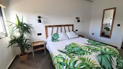 a bedroom with a bed with a plant on it at VILLA OASIS | Casa Rural ideal Familias y grupos in Arcos de la Frontera