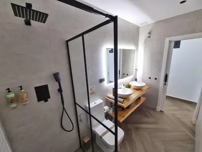 a bathroom with two sinks and a glass shower stall at VILLA OASIS | Casa Rural ideal Familias y grupos in Arcos de la Frontera