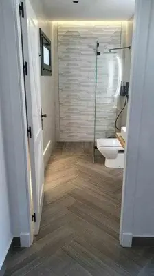 a bathroom with a toilet and a glass shower at VILLA OASIS | Casa Rural ideal Familias y grupos in Arcos de la Frontera