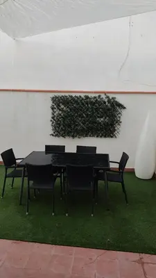 a black table and chairs with a plant on a wall at Casa Babuche in Algar