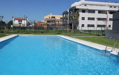 a large blue swimming pool in front of a building at Felipe Frente al rio in Sanlúcar de Barrameda