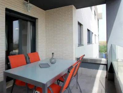 a table with orange chairs sitting on a patio at Felipe Frente al rio in Sanlúcar de Barrameda