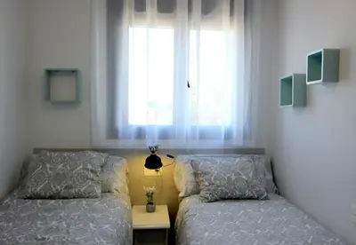 a bedroom with two beds and a window at Felipe Frente al rio in Sanlúcar de Barrameda