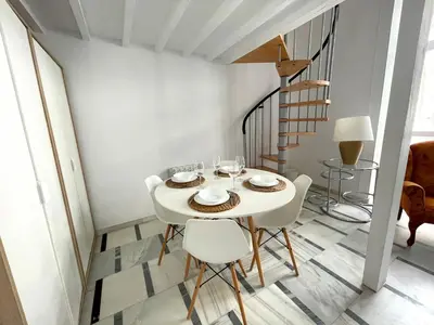 a white dining room with a white table and chairs at No 5 Cádiz in Cádiz