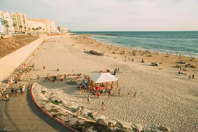 a beach with a lot of people and the ocean at No 5 Cádiz in Cádiz