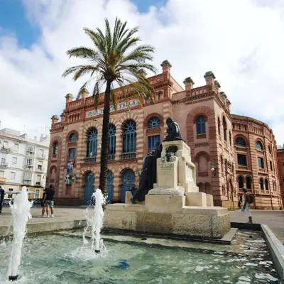 a fountain in front of a building with a statue at No 5 Cádiz in Cádiz