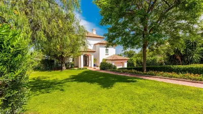 a white house with a green yard with trees at Villa Grazalema 1 - Villa 37 Arcos de la Frontera by Ruralidays in Arcos de la Frontera
