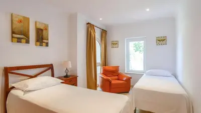 a bedroom with two beds and a chair and a window at Villa Grazalema 2 - Villa 39 Arcos de la Frontera by Ruralidays in Arcos de la Frontera