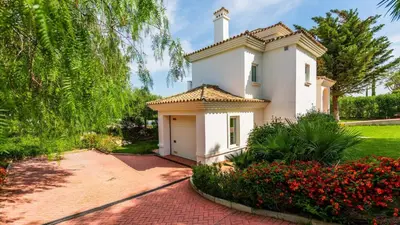 a white house with a small garage in a garden at Villa Grazalema 2 - Villa 39 Arcos de la Frontera by Ruralidays in Arcos de la Frontera