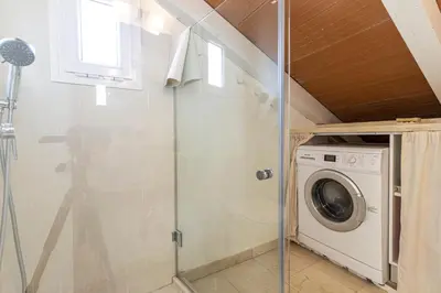 a bathroom with a washer and dryer at Penthouse Arenal - Boutique Puerta Real in Jerez de la Frontera