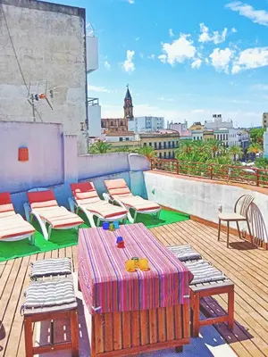 a patio with chairs and tables on a roof at Penthouse Arenal - Boutique Puerta Real in Jerez de la Frontera