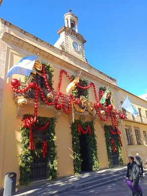 a building covered in christmas decorations with a clock tower at Penthouse Arenal - Boutique Puerta Real in Jerez de la Frontera
