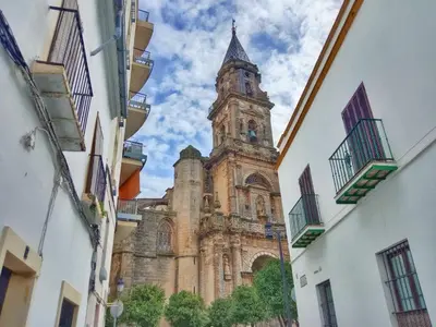 an old building with a clock tower in the distance at Penthouse Arenal - Boutique Puerta Real in Jerez de la Frontera