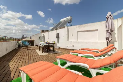 a deck with chairs and a table on a building at Penthouse Arenal - Boutique Puerta Real in Jerez de la Frontera