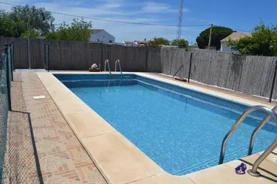 a swimming pool in front of a wooden fence at El Moral in Cádiz